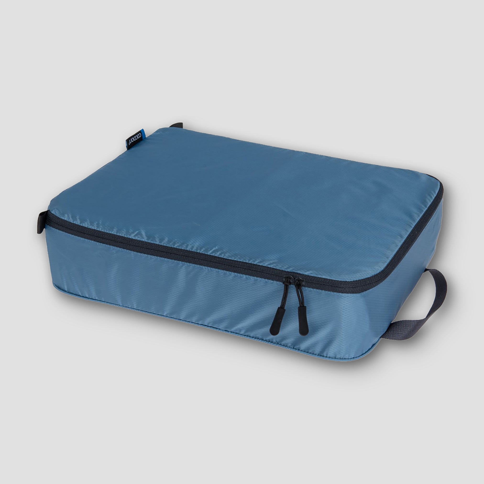 COCOON Discrete Light Travel Packing Cubes in various sizes for organized luggage storage.