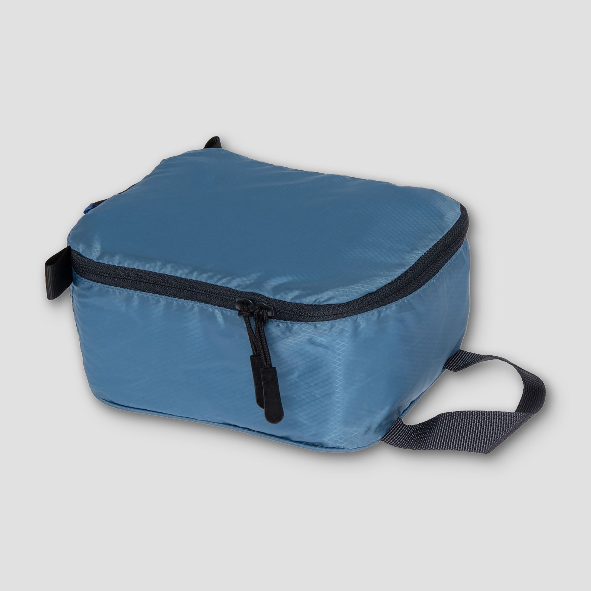 Cocoon Discrete Light Packing Cubes for travel organizers, showing compact, lightweight fabric cubes with zipper closures.